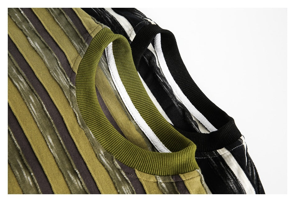 Close-up of ribbed crew necks and striped fabric in olive and black-and-cream shirt colorways.
