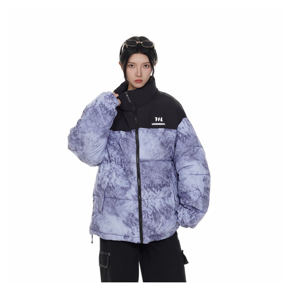 Close-up of model wearing the black and blue marbled puffer jacket zipped, with stand collar and chest logo
