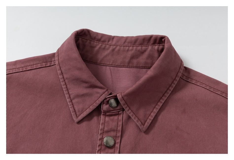 Close-up of the dusty mauve overshirt's pointed collar, shoulder seams, and metal snap buttons.