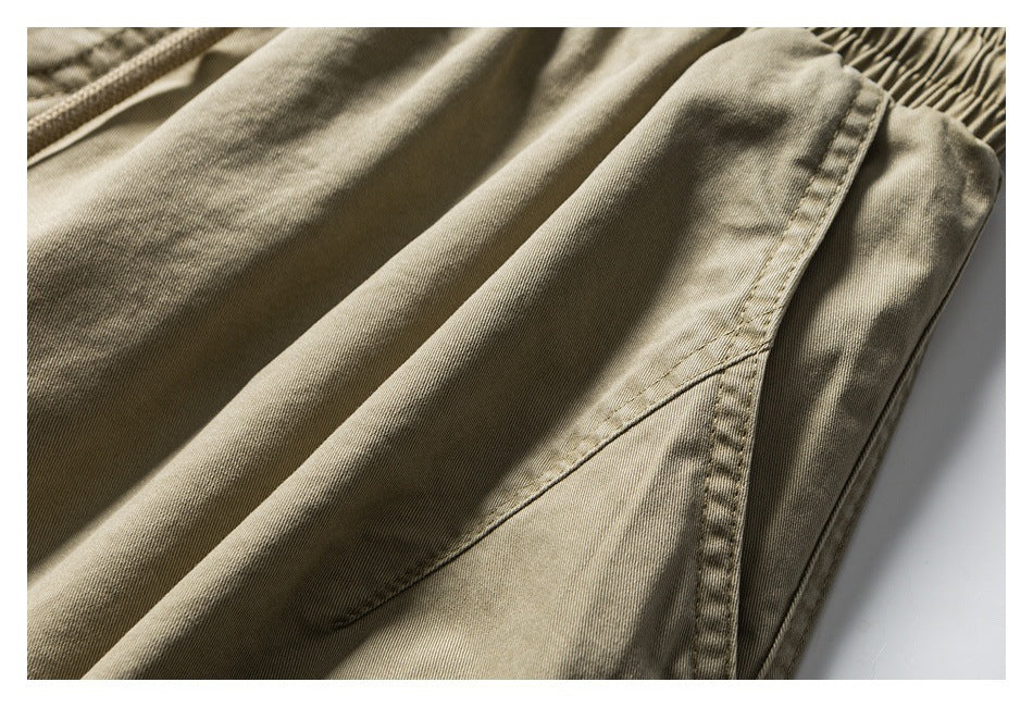Close-up of khaki shorts showing a curved pocket seam beside the gathered waistband.