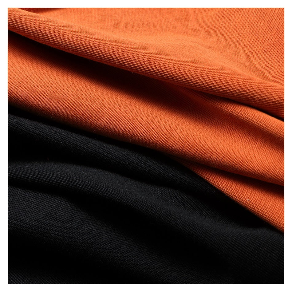 Folded orange and black fabric shown together in close-up.