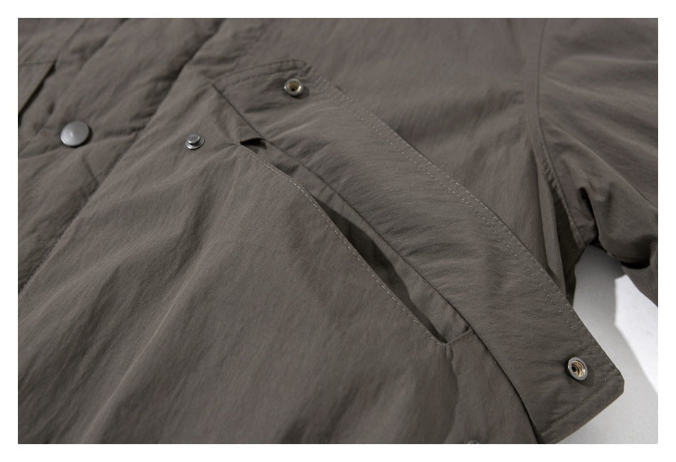 Close-up of the charcoal gray jacket's snap-button front placket and angled pocket opening.
