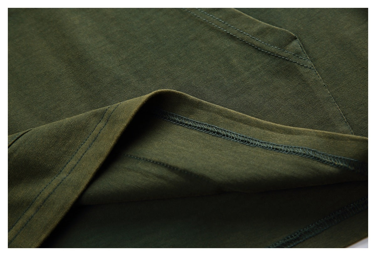 Close-up of olive-green garment fabric showing folded edges and overlocked seam stitching.