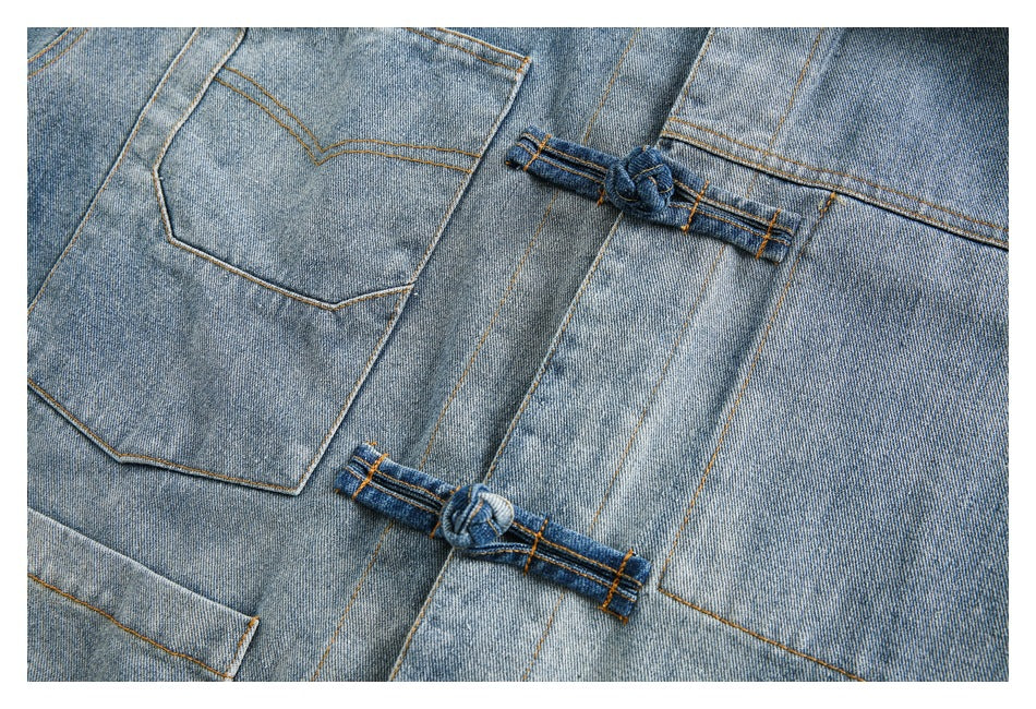 Close-up of the denim jacket's patch pocket, vertical seams, and two knotted denim closures.