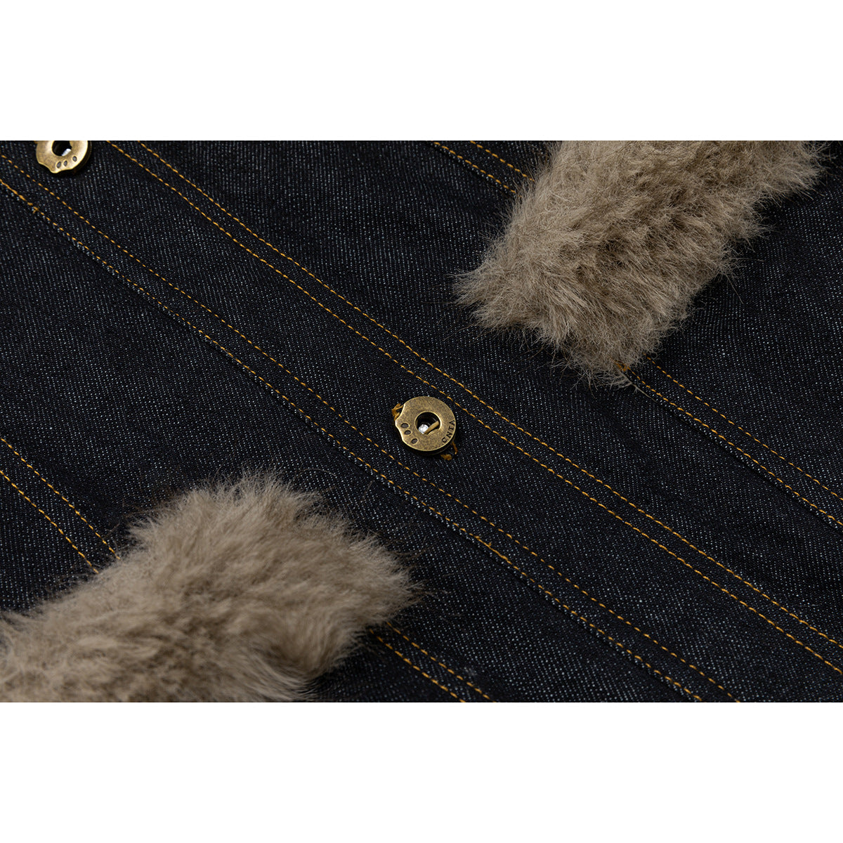 Close-up of dark denim, gold-tone buttons, contrast stitching and tan faux-fur trim.