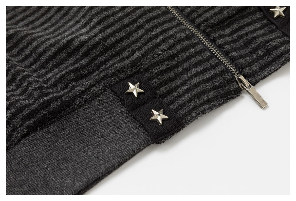 Close-up of the jacket's striped fabric, metal zipper, ribbed hem, and silver star studs.