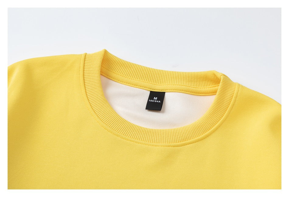 Close-up of a yellow sweatshirt's ribbed crew neckline and inner size tag marked M and 160/84A.