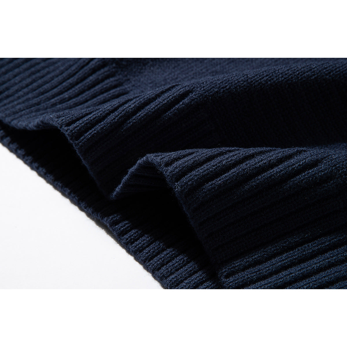 Close-up of the ribbed hem and knit texture on a dark navy sweater vest.