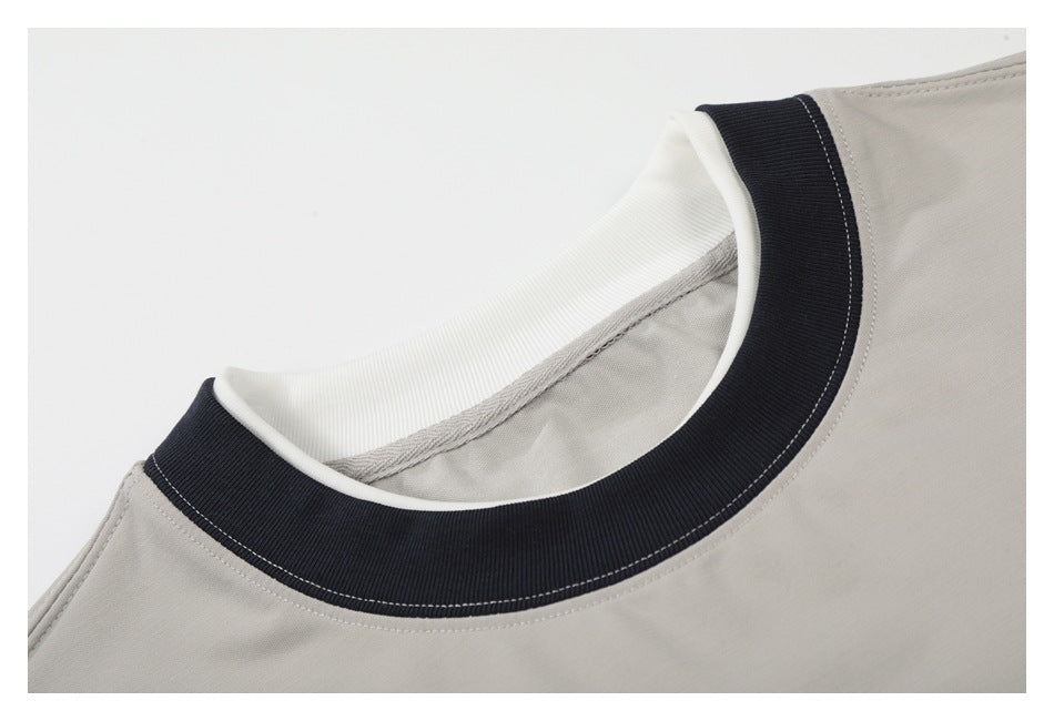 Close-up of a light gray T-shirt's black ribbed crew neck collar and inner neckline.