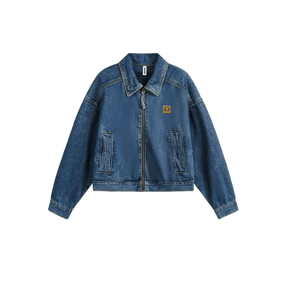 Cropped blue washed denim jacket flat view with front zipper, collar, two front pockets and star chest patch