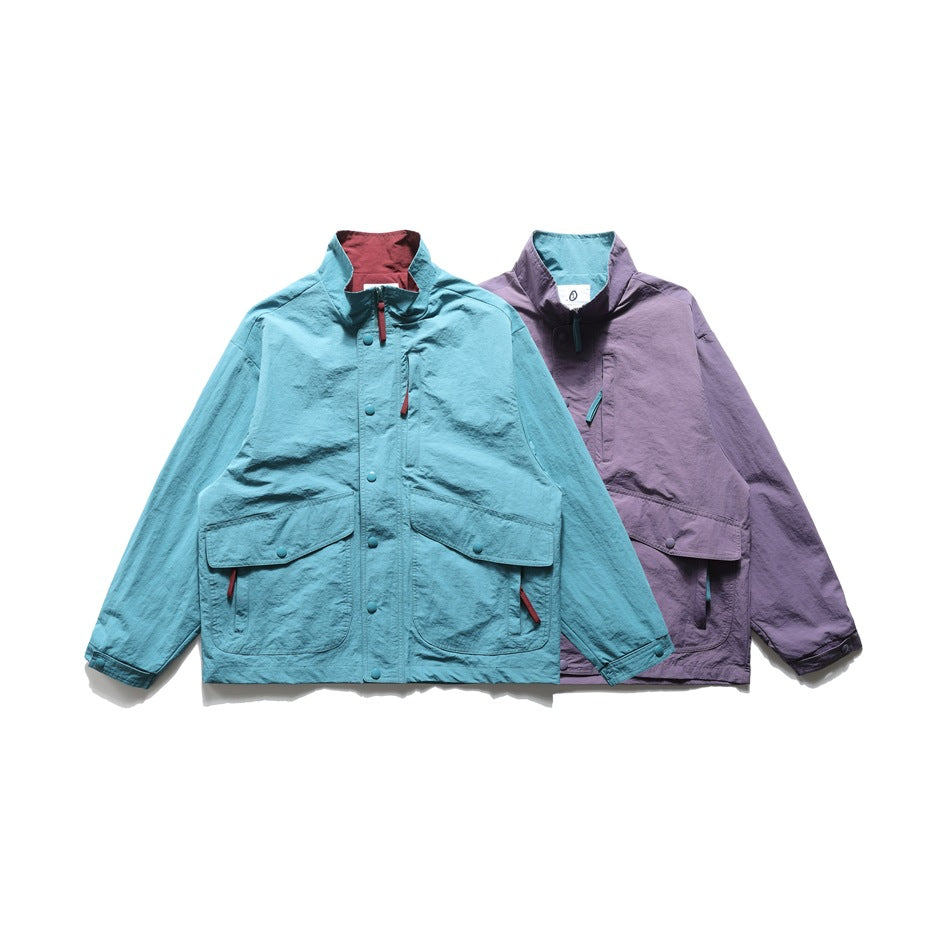 Two jackets shown from the front: turquoise in front and plum behind, both with stand collars and large flap pockets.