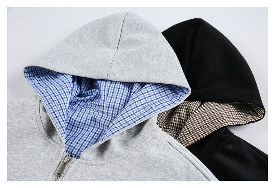Close-up of gray and black zip-up hoodie hoods with blue and brown plaid linings.