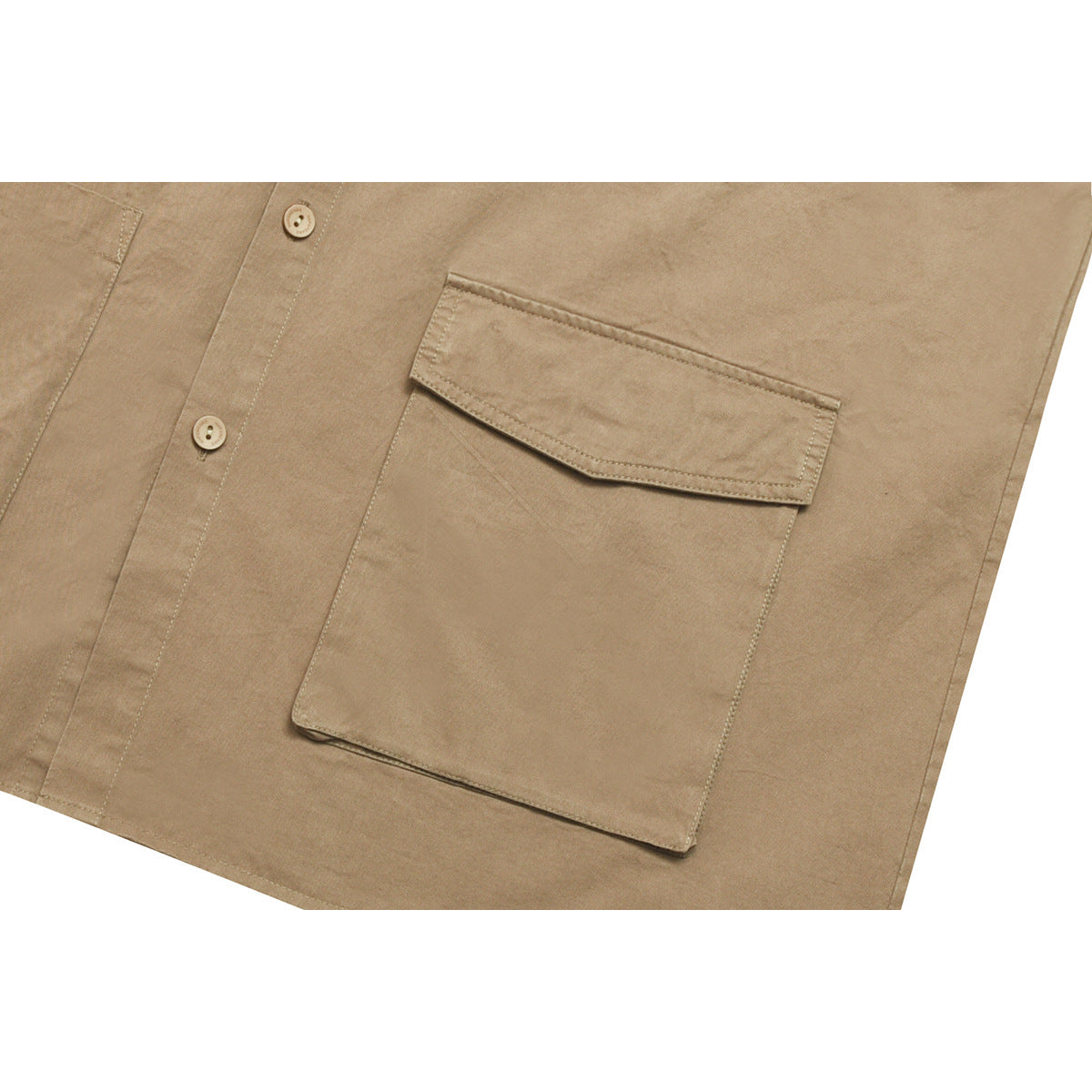Close-up of a tan shirt's large button-flap chest pocket and front buttons.
