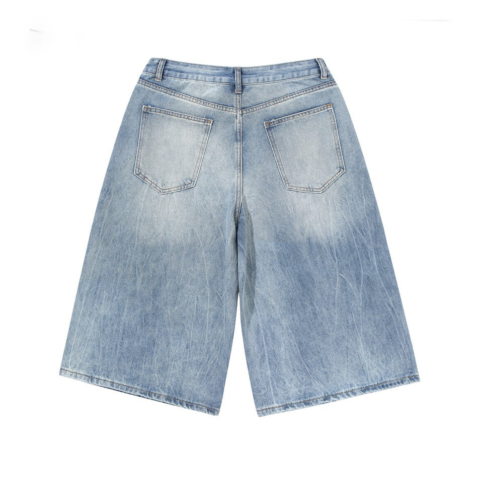Back view of light-wash, wide-leg denim shorts with two patch pockets and belt loops.