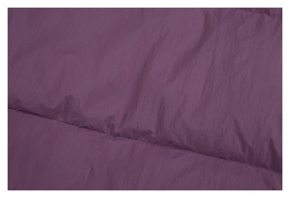 Close-up of plum-purple jacket fabric and a diagonal stitched quilt seam.
