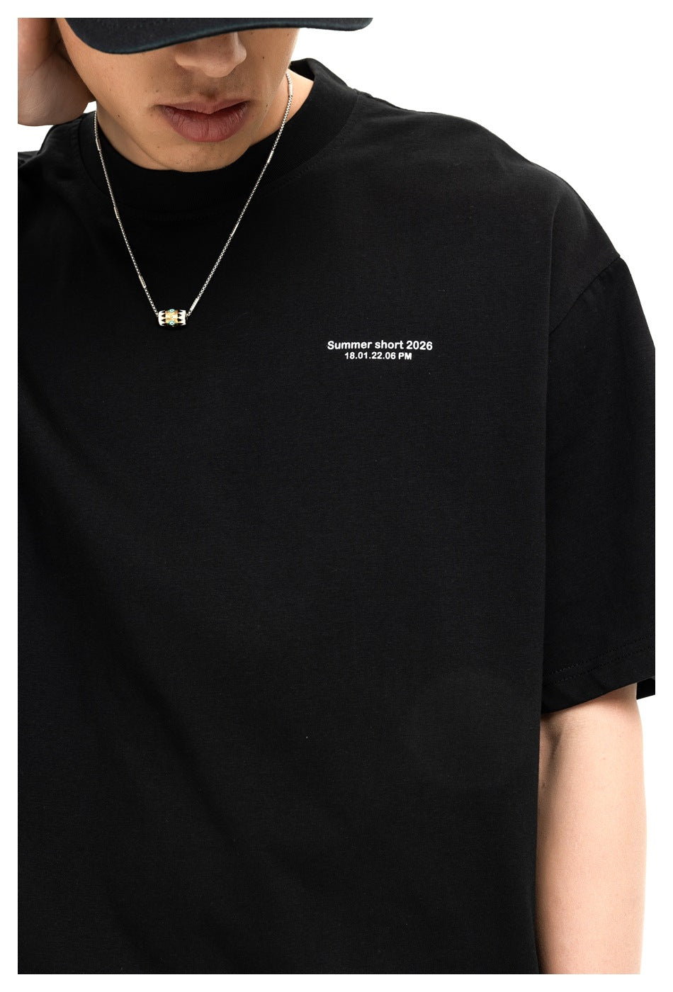 Close-up of a person wearing a black crew-neck T-shirt with small white text on the chest.