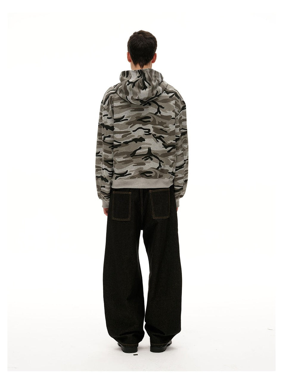 Back view of a model wearing a gray camouflage hooded sweatshirt and loose black jeans.