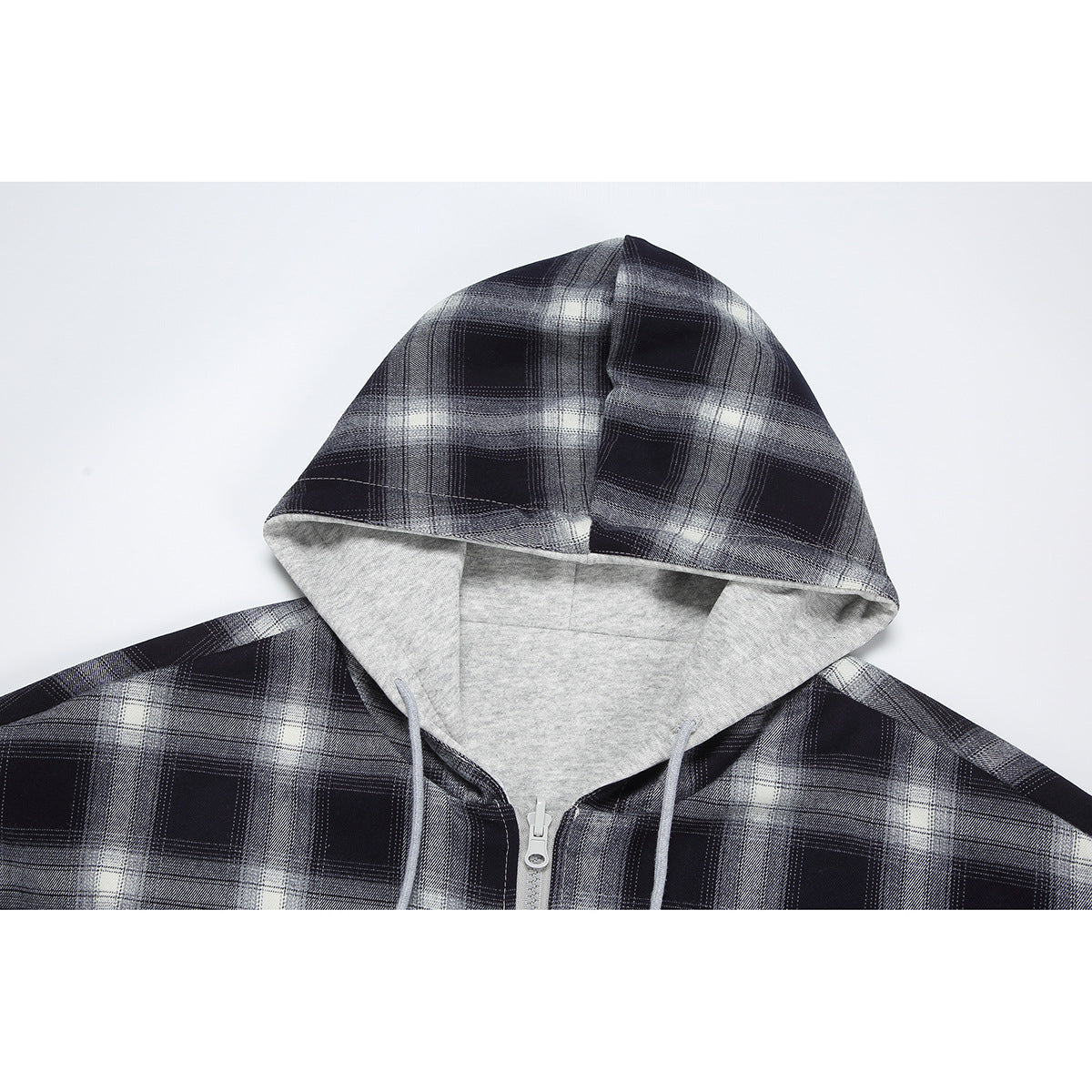Close-up of a black-and-gray plaid zip hoodie showing its light gray lined hood and drawstrings.