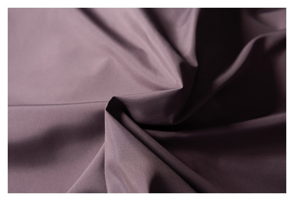 Close-up of smooth mauve fabric arranged in deep folds.