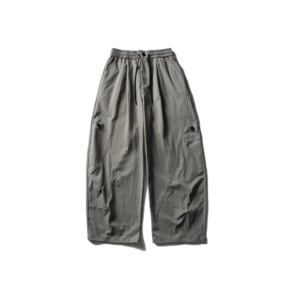 Gray-green wide-leg pants flat lay, front view, with elastic drawstring waist and curved diagonal seams