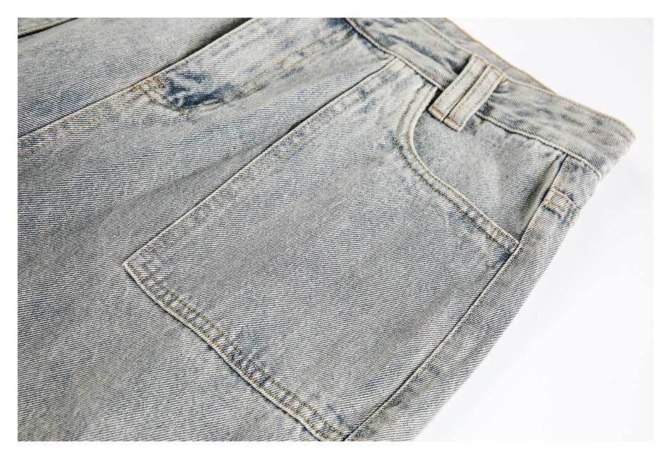 Close-up of a front pocket, belt loop, and faded washed texture on the light gray jeans.