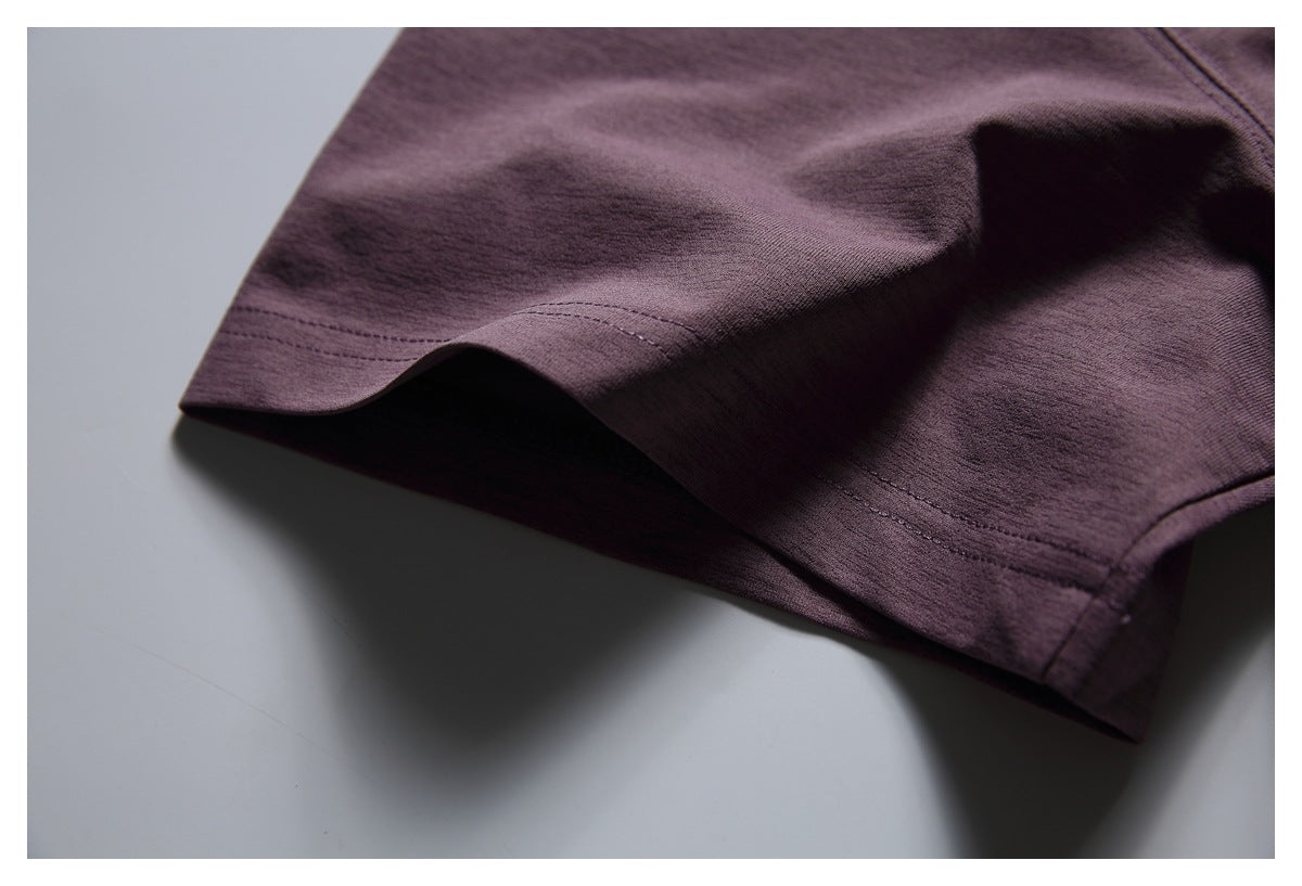 Close-up of the muted plum T-shirt's short sleeve and stitched hem.