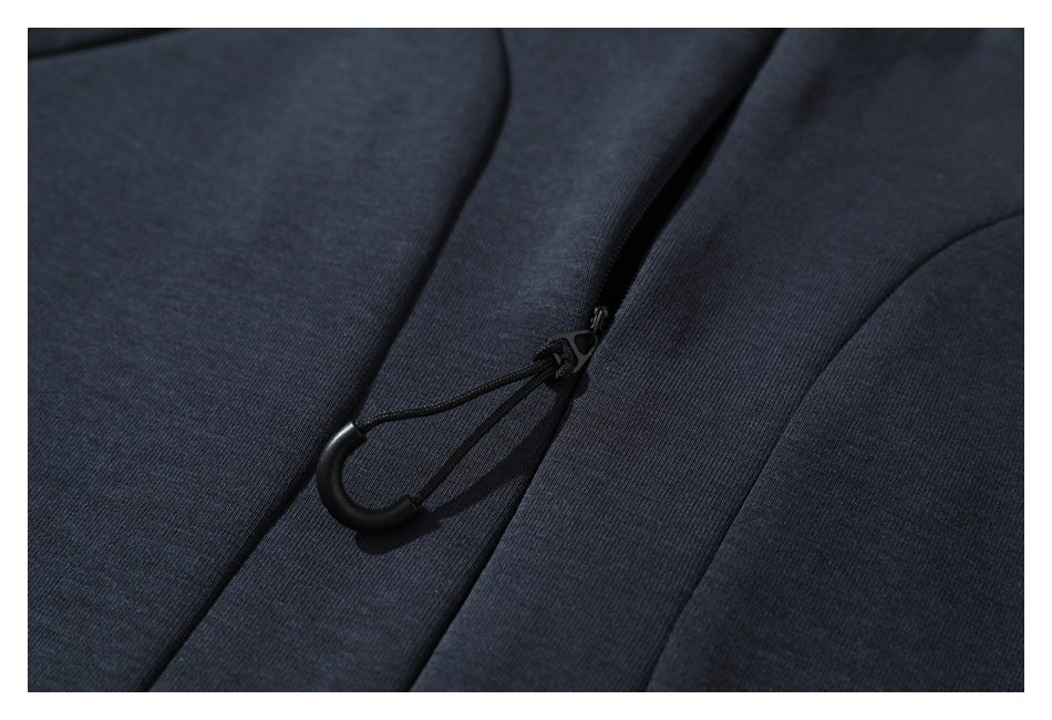 Close-up of a black drawcord toggle on the placket of a dark navy garment.