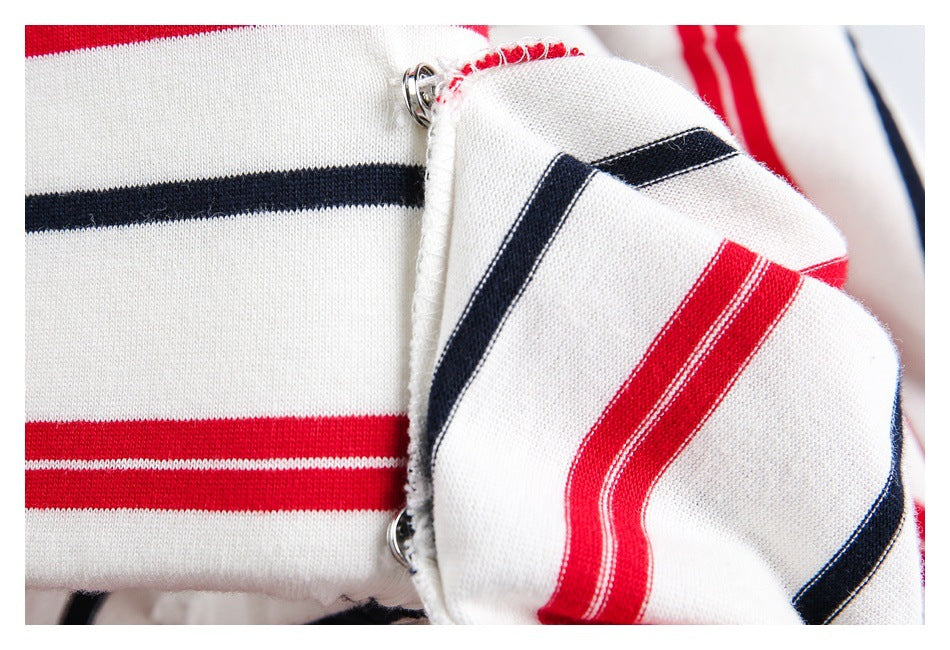 Close-up of a striped shirt cuff with metal snap fasteners and visible stitching.