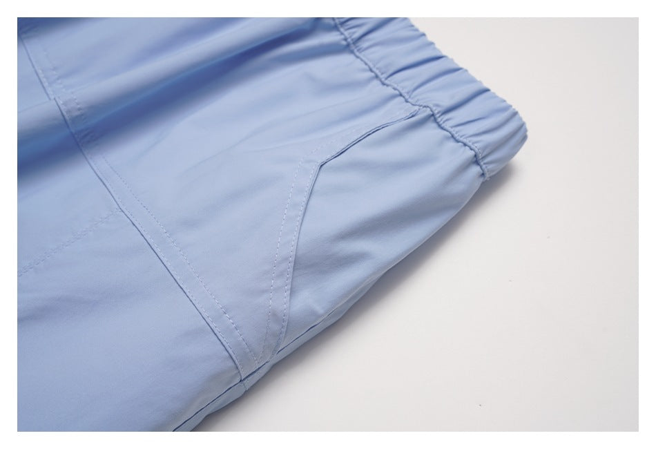 Close-up of a stitched pocket opening and panel seams on the pale blue skirt.
