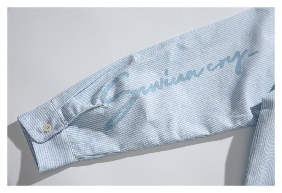 Light blue and white striped shirt sleeve with a buttoned cuff and large blue script print.