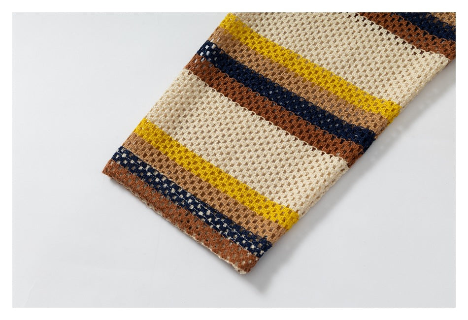 Close-up of a garment edge showing cream open-knit fabric with mustard, tan, navy, and rust stripes.