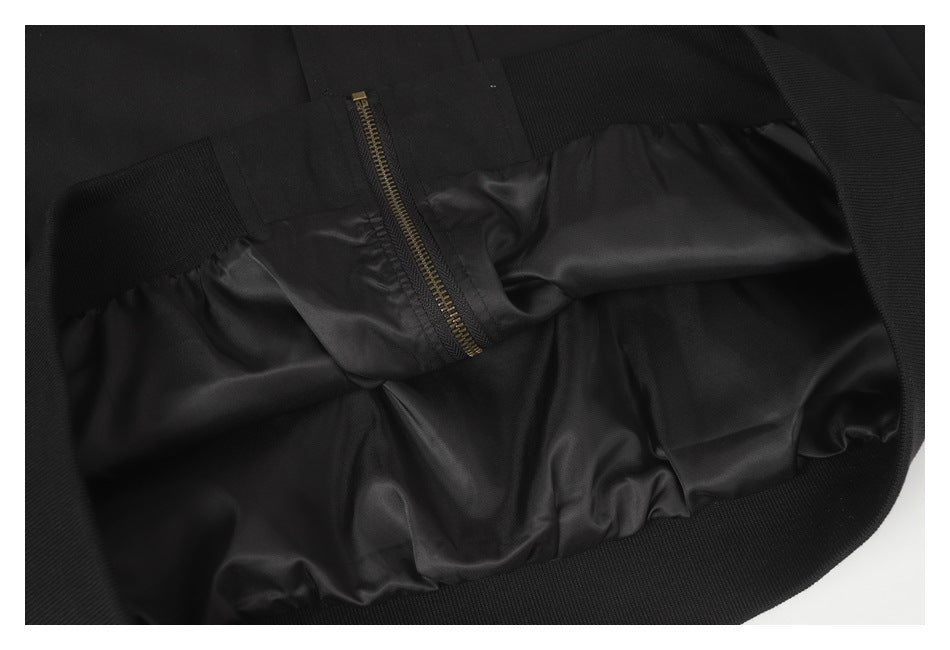 Close-up of the black garment's interior lining and a brass-tone zipper.