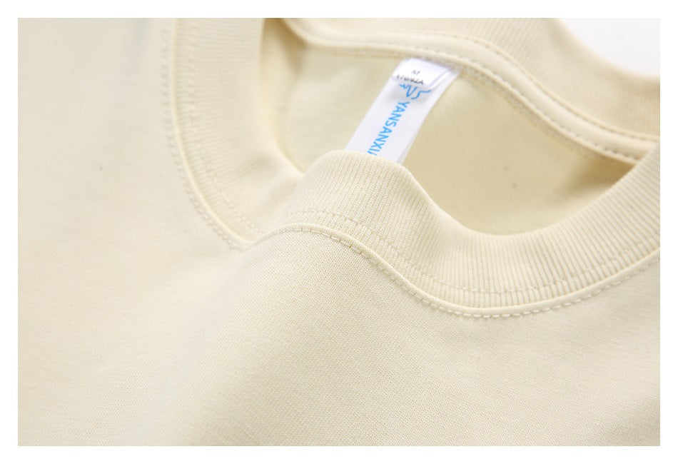 Close-up of a ribbed cream crew neck and a small sewn-in neck label.