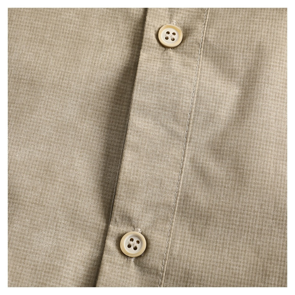 Close-up of a beige micro-check shirt placket with two cream four-hole buttons.