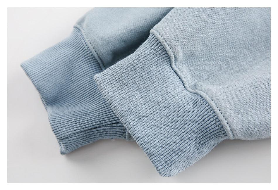 Close-up of two pale blue sweatshirt cuffs with wide ribbed bands.