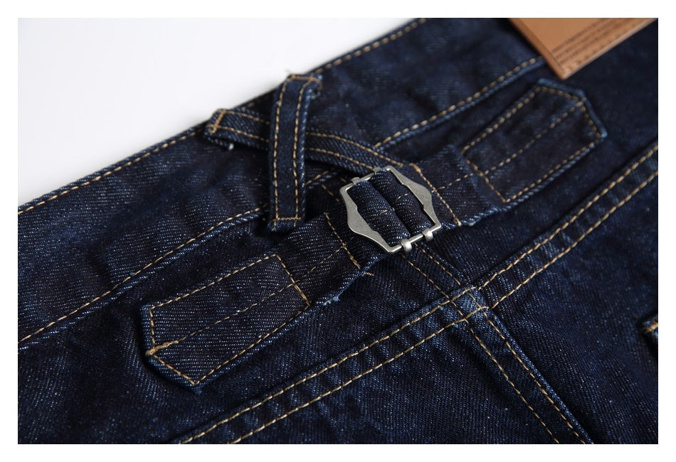Close-up of the jeans' waistband with belt loops, a metal buckle detail and tan contrast stitching.
