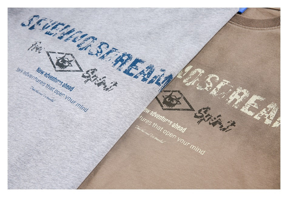 Heather gray and taupe crewneck tops shown together with distressed outdoor-themed front graphics.
