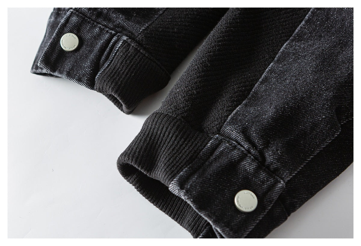 Close-up of black ribbed cuffs and silver snap-button tabs on a garment.