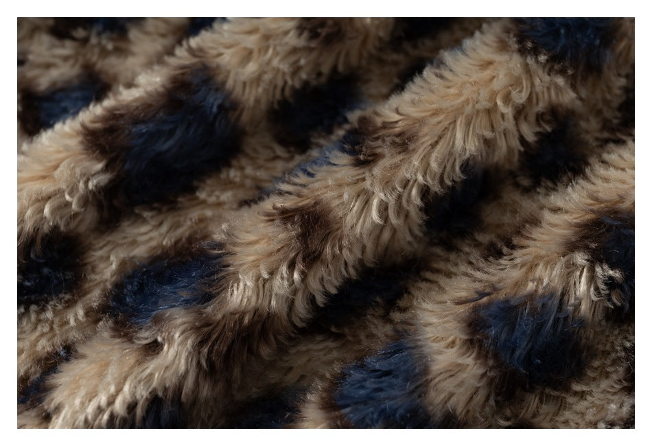 Extreme close-up of the jacket's shaggy tan-and-navy spotted plush texture.