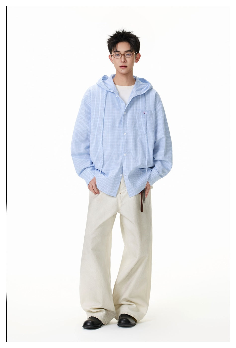 Full-length front view of a model wearing a light blue checked hooded shirt and cream wide-leg trousers.