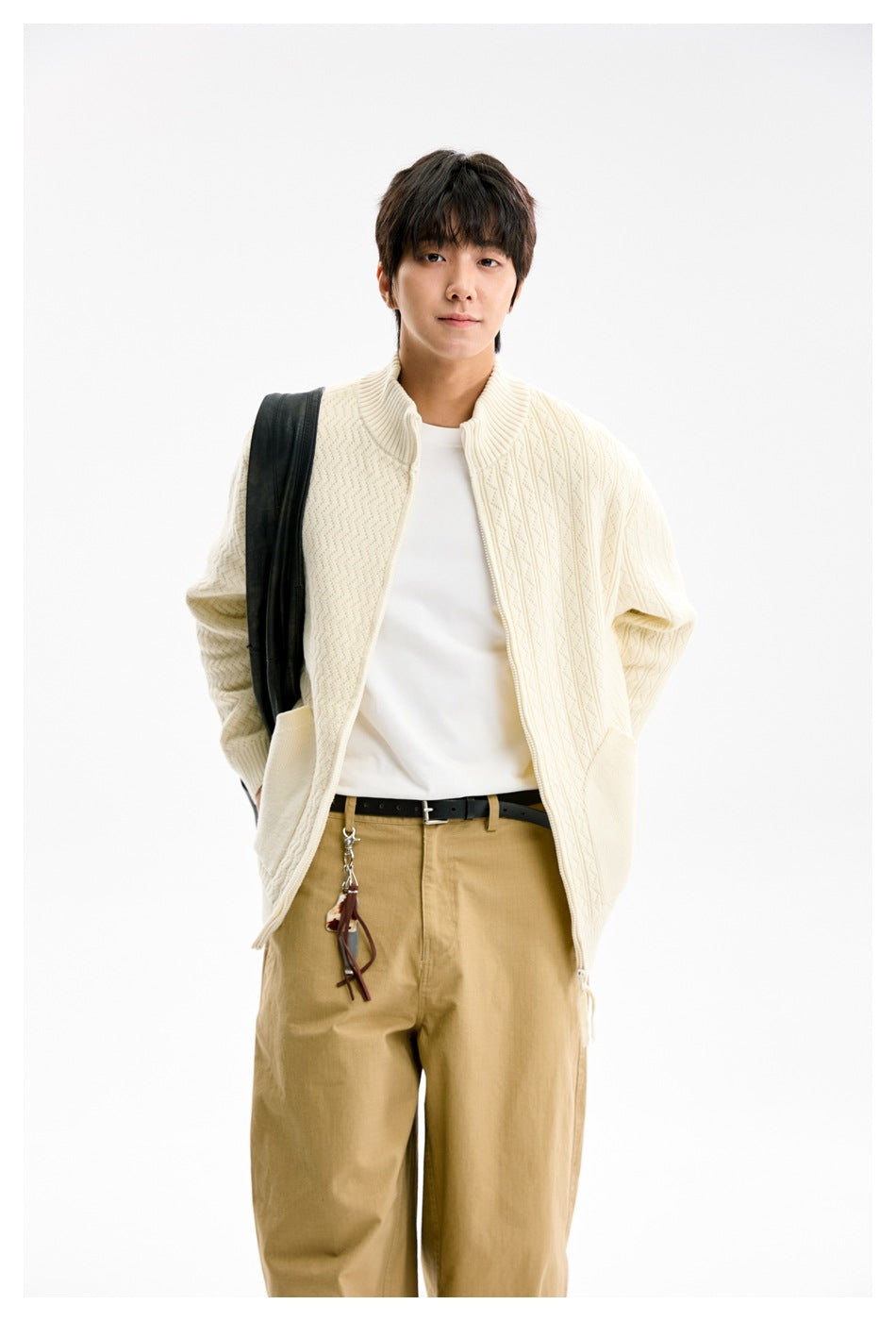 Model wearing an open ivory textured knit zip cardigan with large front pockets.