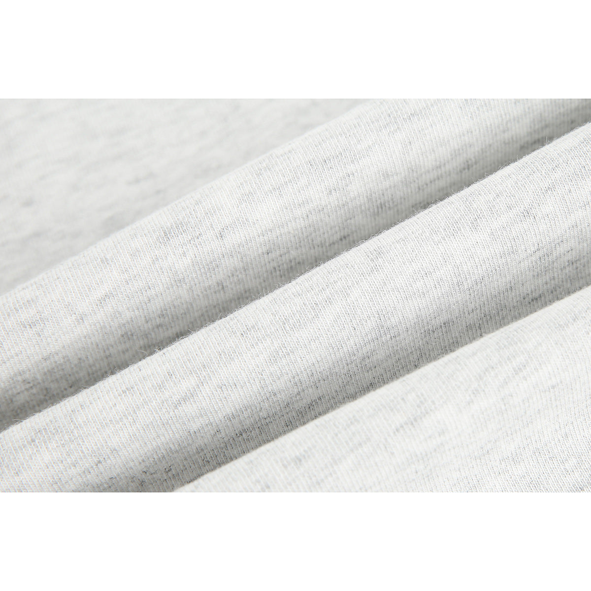 Macro view of light gray knit fabric arranged in soft folds.