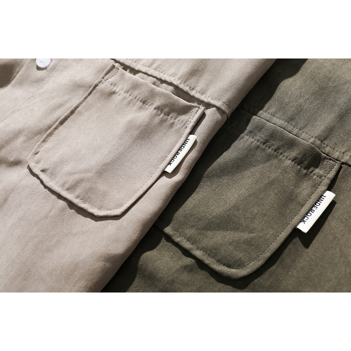 Close-up of taupe and olive shirt chest pockets with stitched edges and small white side labels.
