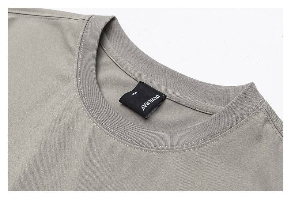 Close-up of a gray crew-neck shirt highlighting the ribbed collar, seams, and sewn-in label.
