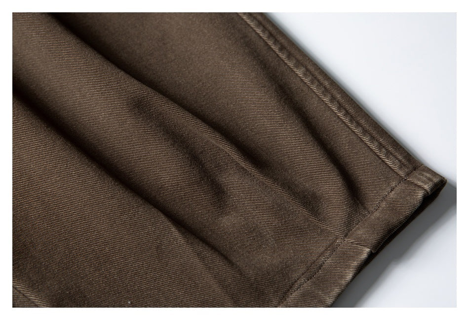 Close-up of a dark brown trouser leg hem and stitched seam.