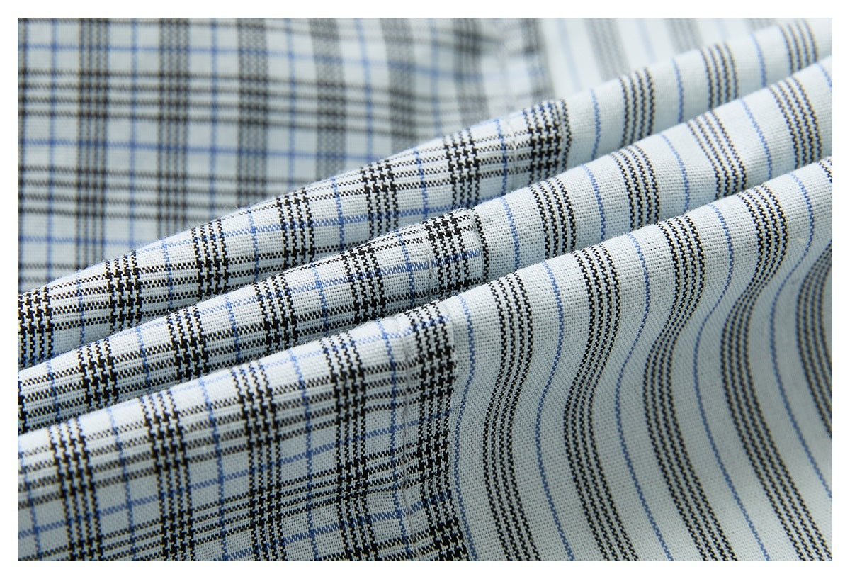 Macro view of the white shirt fabric showing black and pale blue plaid alongside fine vertical stripes.