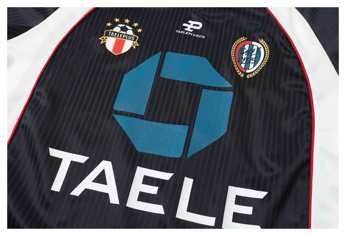 Close-up of the jersey front showing colorful emblems and large white lettering on dark pinstripes.