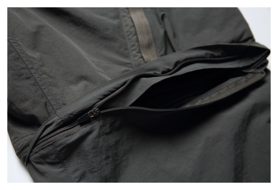 Close-up of an open zippered pocket on charcoal shorts.