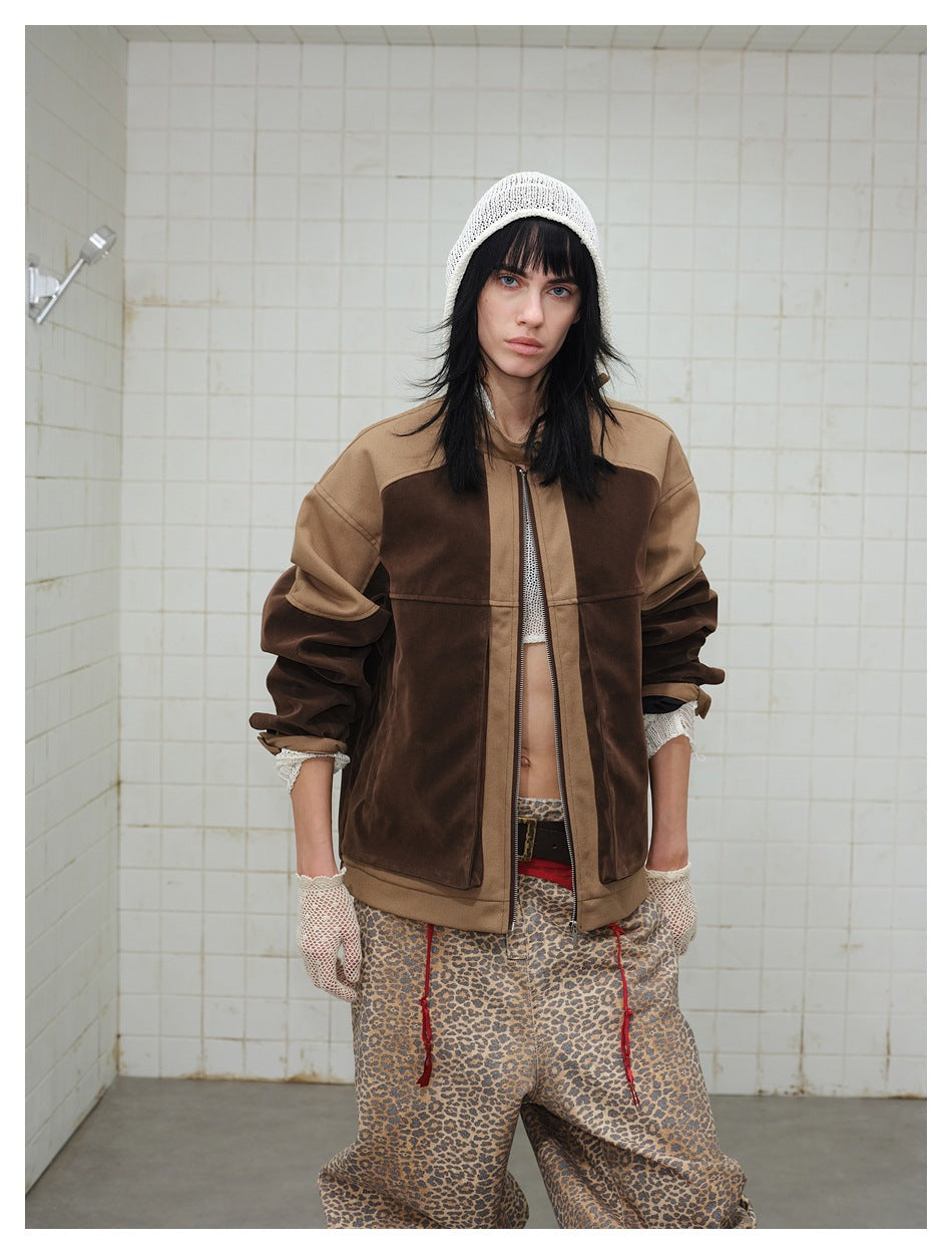 Front view of a model wearing a brown and tan color-block zip jacket with a white knit cap and leopard-print trousers.