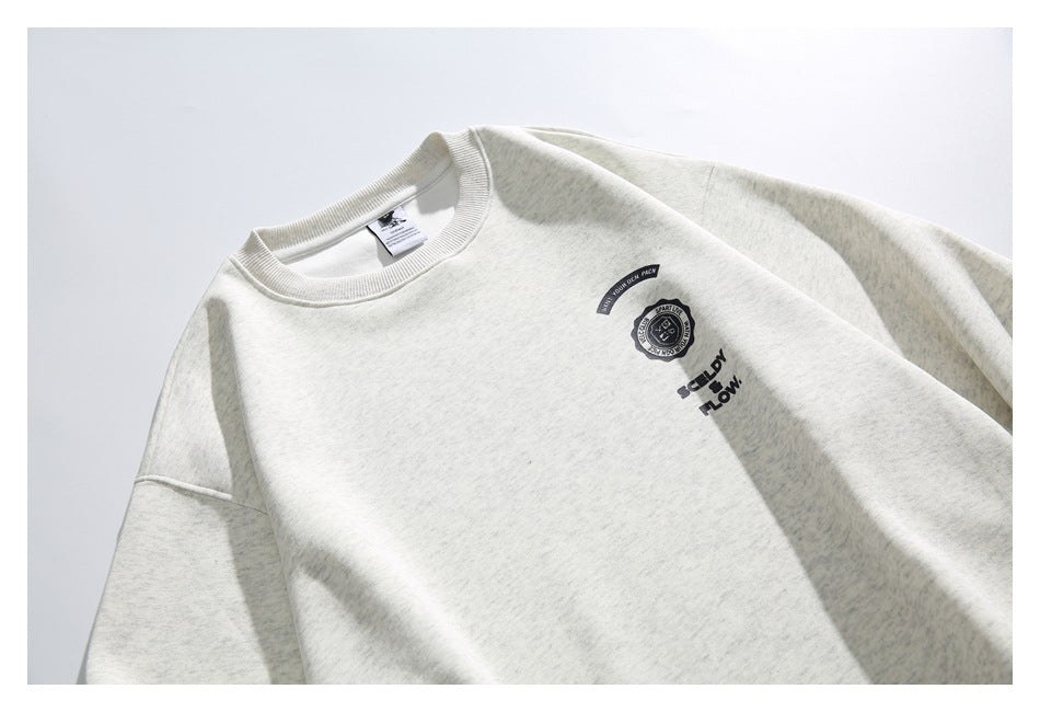 Close view of an off-white heathered crewneck sweatshirt with small black graphics on the chest.